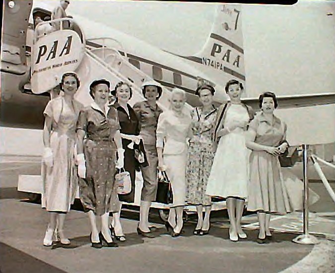 1950s Group of customers pose by the tail of a DC7 Clipper.